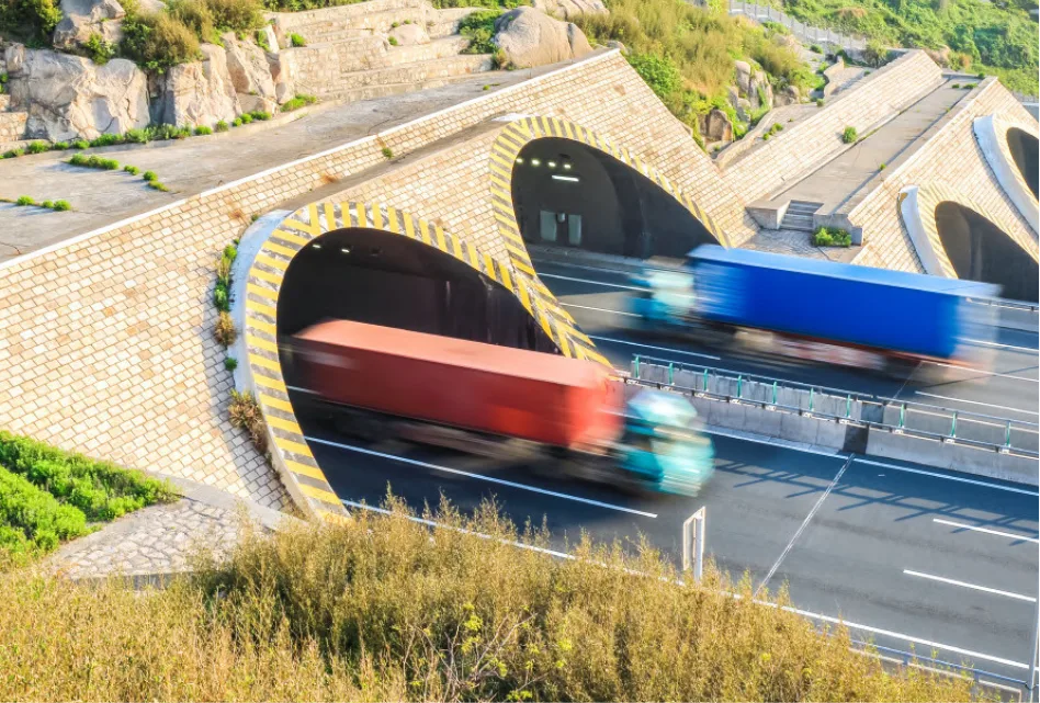Trucks passing through innovative road tunnels, highlighting efficient freight logistics and transportation solutions.