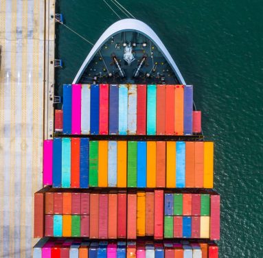 Konteinerių laivo pakrovimas ir iškrovimas giliavandeniame uoste, Verslo logistikos importo ir eksporto krovinių gabenimas konteineriniu laivu atviroje jūroje iš viršaus.
